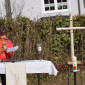 ein Kind liest die Fürbitten am Altar, daneben das neue Birkenkreuz