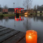 Eisweiher mit einer Kerze am Steg und erleuchtetem Pavillon (Weihnachten 2023)
