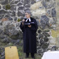 Pfarrerin Steiner steht bei der Predigt vor der Burgmauer
