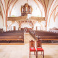 Blick auf Orgel und Empore der St. Johannis-Kirche mit für eine Hochzeit mit Luftballons geschmückten Mittelgang  (© Oskar Burkhardt)