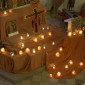 seitlöicher Blick auf den Taizé-Altar mit viele brennenden Kerzen vor dem Taizékreuz
