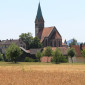 Gesamtbild der St. Johannis-Kirche vor der Reservierung mit Blick aus Nordwesten mit Wirbenz und Getreidefeld (© KG Wirbenz)