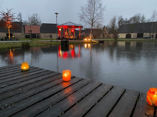 Eisweiher mit Kerzen am Steg und erleuchtetem Pavillon (Weihnachten 2023)