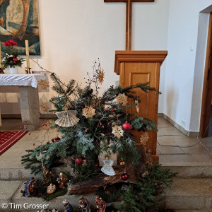 zu Weihnachten 2023 geschmückter Altar mit Kreuz in der Friedenskirche