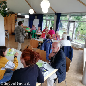 Gottesdienstbesuchende sitzen im Gemeindehaus bei Kaffee und Kuchen zusammen